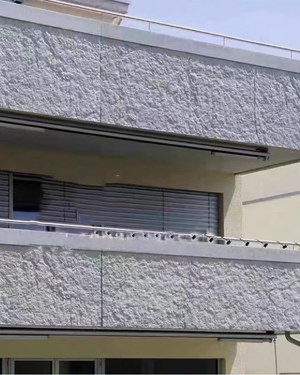 Residential façade clad in white textured MCM