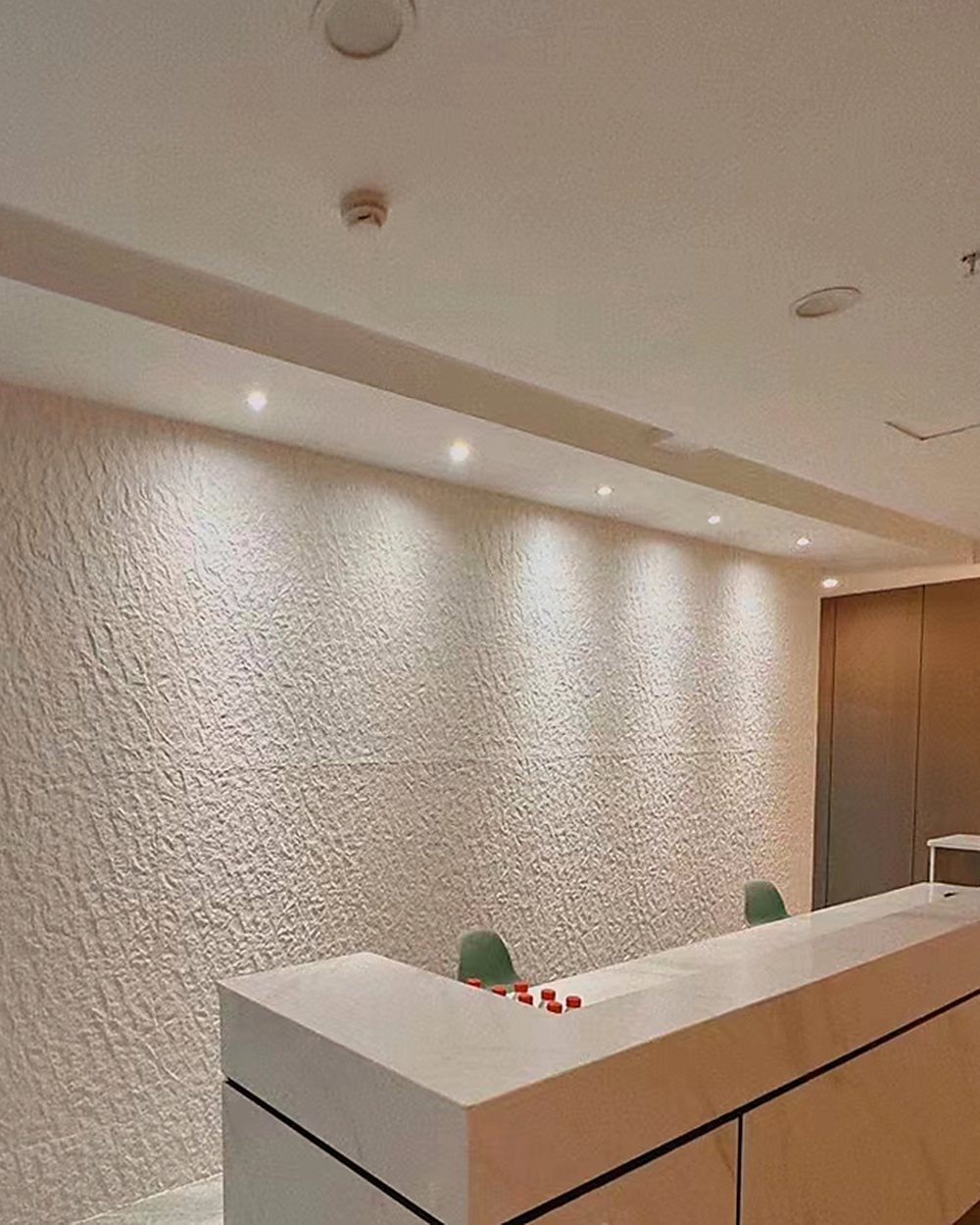 Reception wall in white MCM under grazing downlights